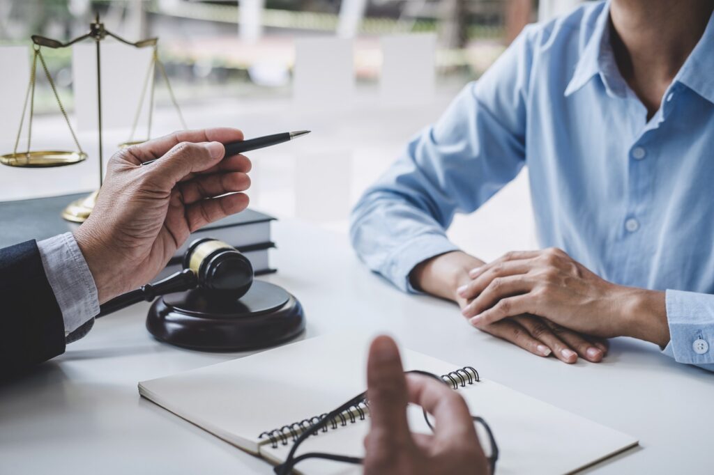 A notary public discussing legal details with a client, with a gavel and scales of justice symbolizing legal authority.