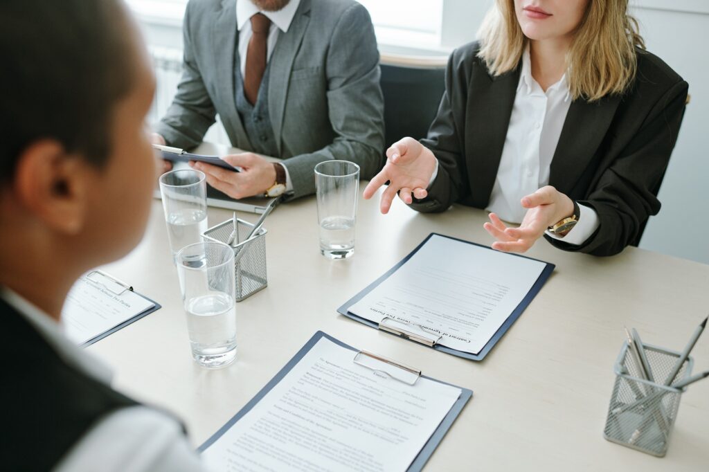 A professional meeting where a notary public and clients review legal documents to ensure everything is in order for notarization.
