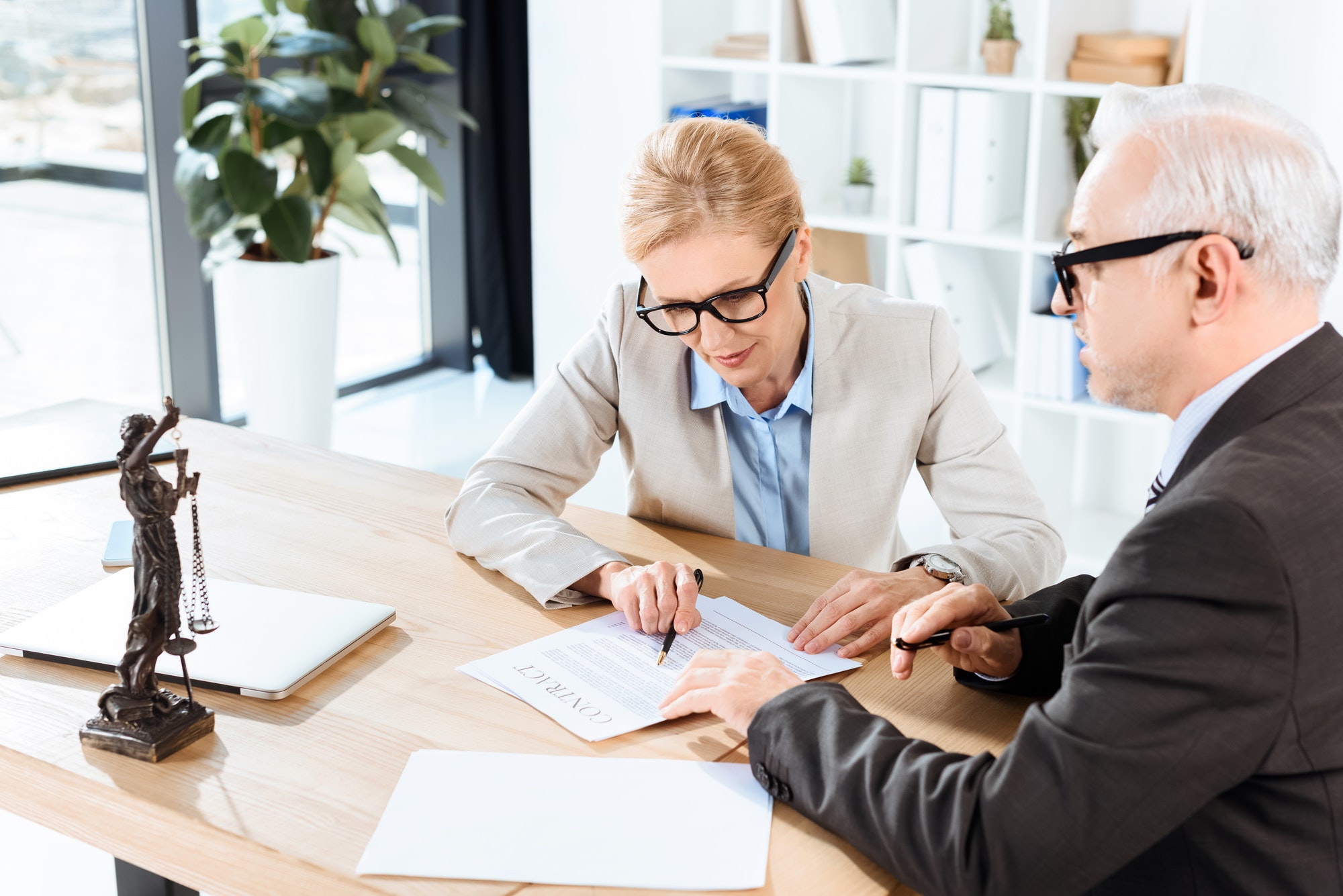 Two professionals reviewing a notary document, ensuring all details are correct before notarization.